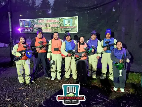 Equipo jugando de noche frente al letrero de Quito Woodsball